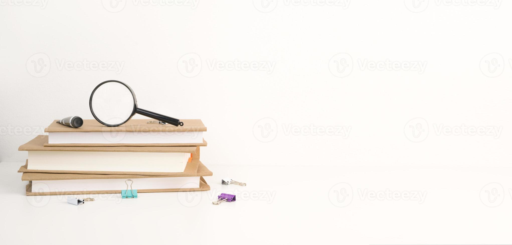 Stack of books with magnifier on top.Back to school.Copyspace banner photo