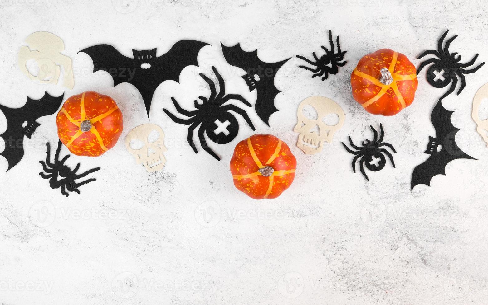Halloween celebration flatlay with pumkins,bats,spiders and skulls. Copyspace banner. October holidays. photo