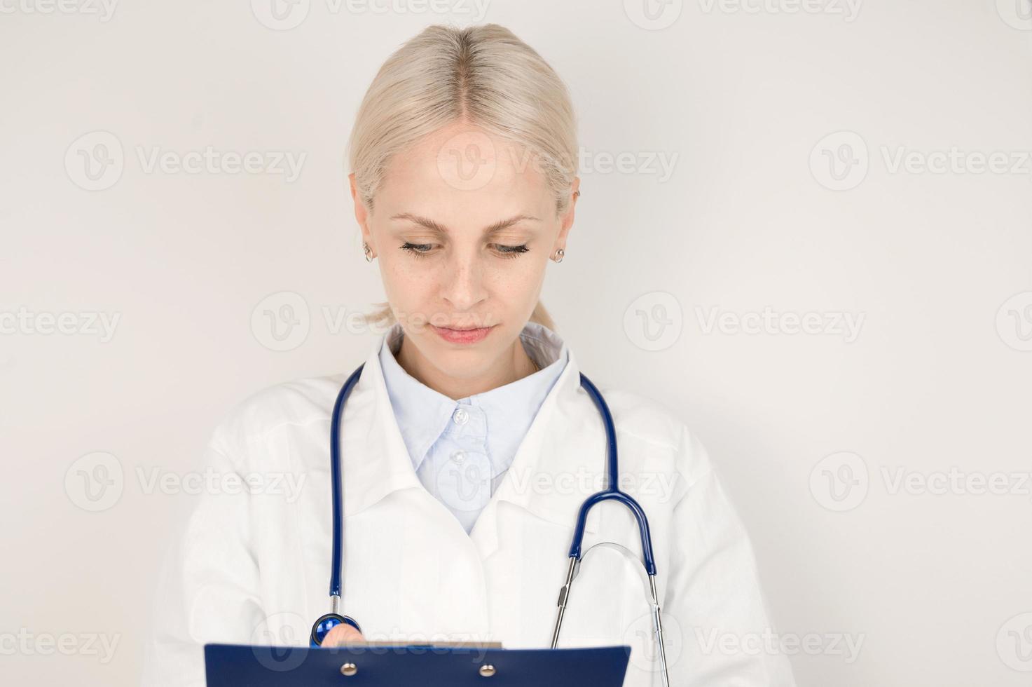 joven doctora tomando notas en tableta de papel. concepto de salud foto