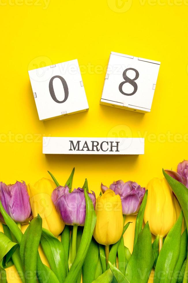 Vertical card with 8 march concept. Colorful tulips on yellow purple. International women's day photo