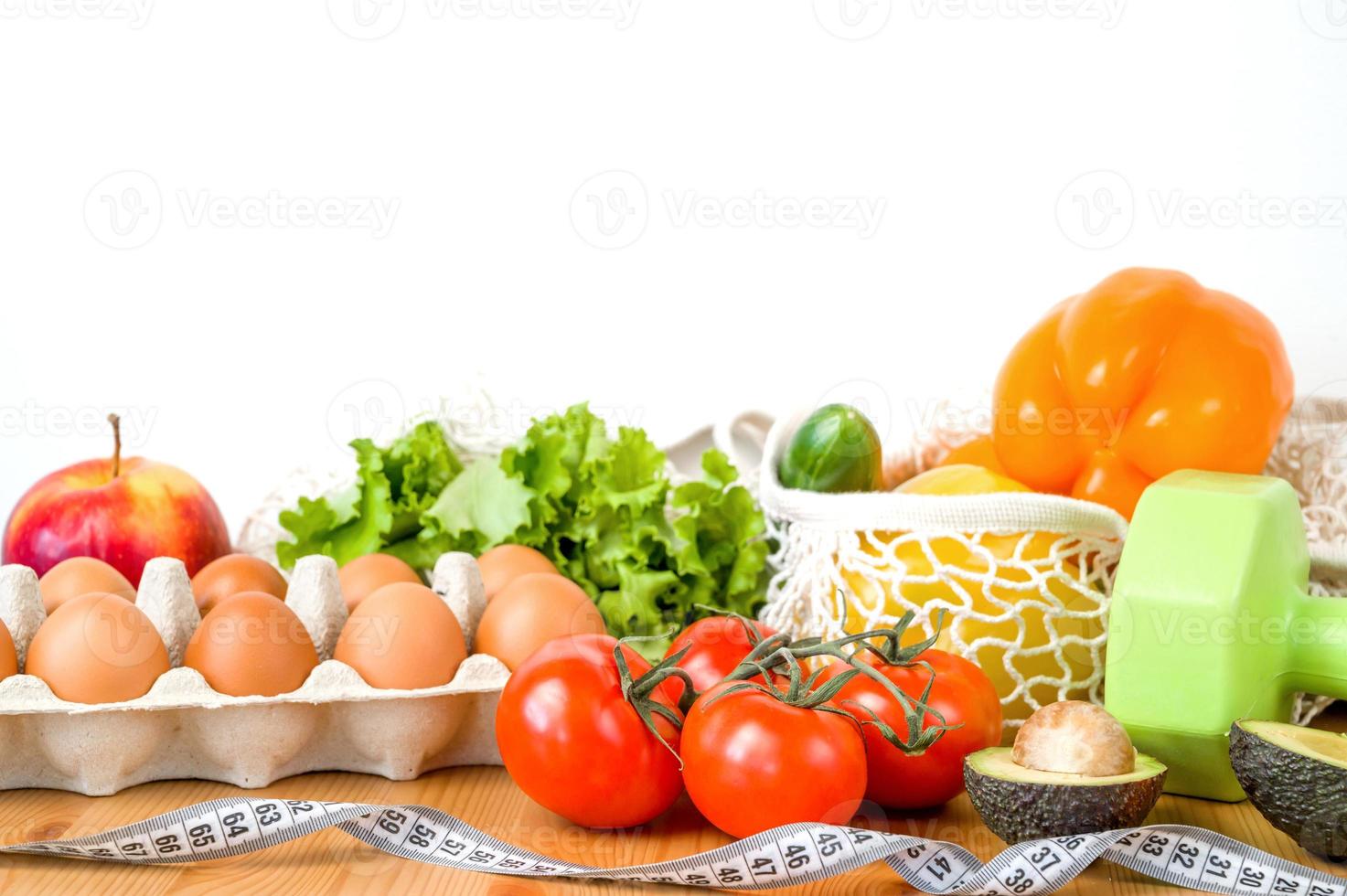 Vegetables anf fruit near dumbbells and measuring tape. Sport and diet concept. HEalthy lifestyle photo