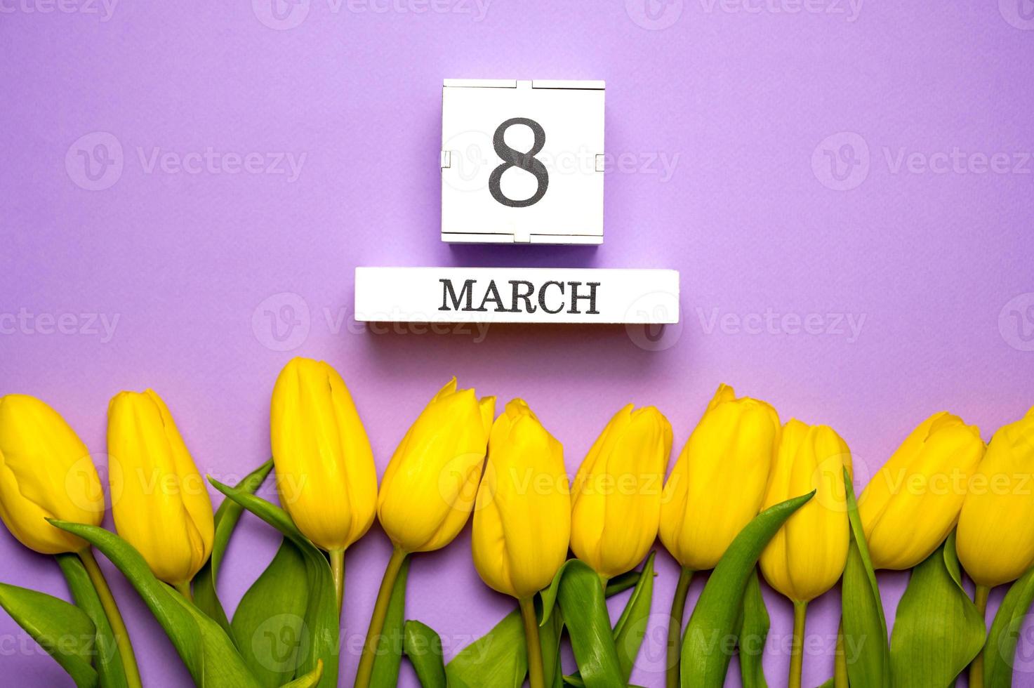 8 march flat lay. Calendar with date lies surrounded with yellow tulips photo