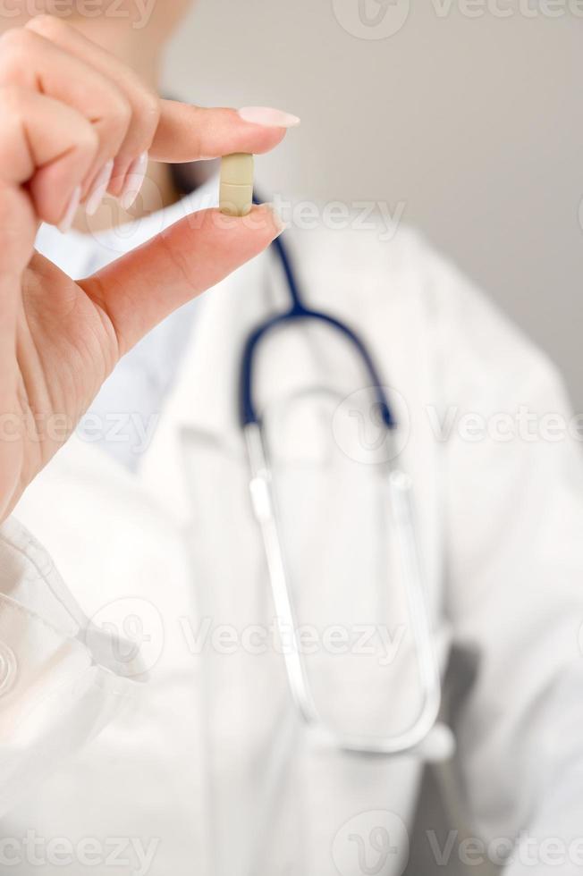 Healthcare and medication vertical banner with doctor holding pill. photo