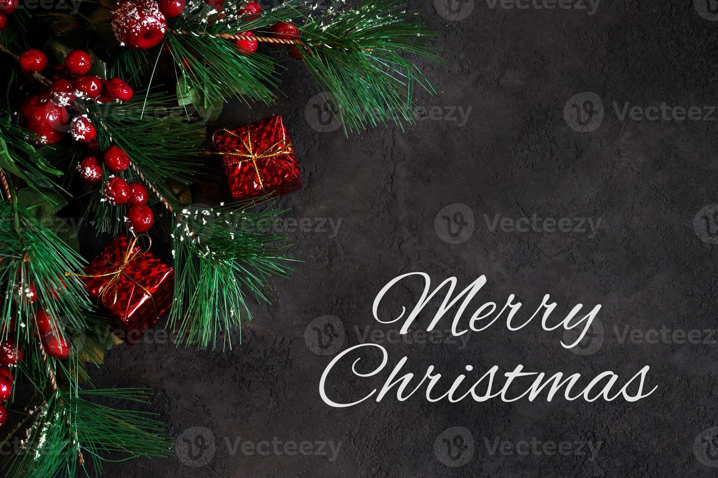 Winter holidays greeting card with Merry chirstmas text. Flalt lay with green pine branches photo