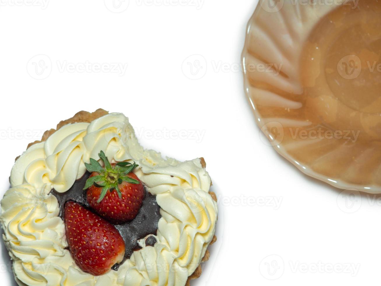 Cake with butter cream and strawberries. Sweetness on a white background. Treat for tea.  bitten cake and plate photo