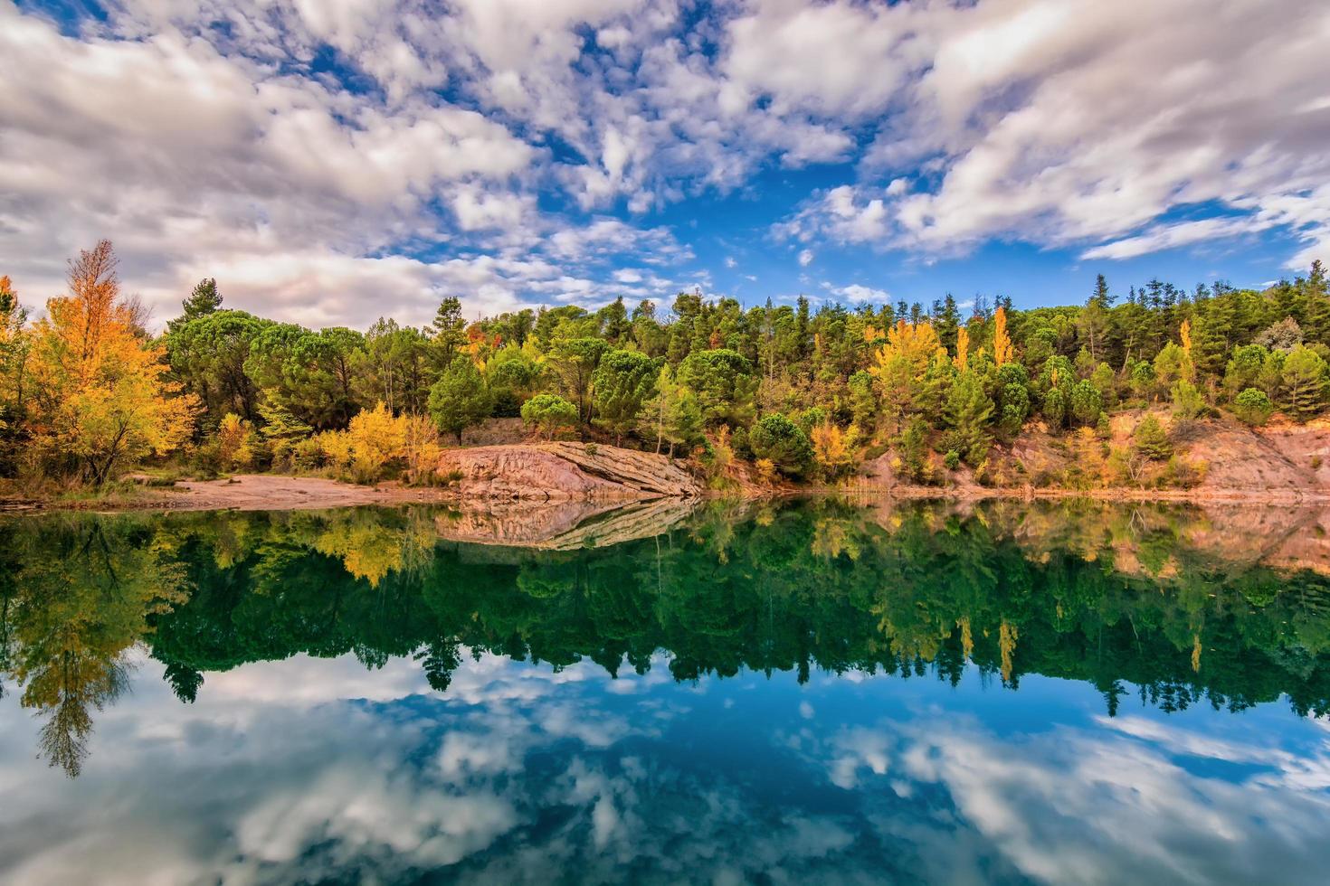 vista escénica del espejo como reflejo del lago carces en el sur de francia en colores otoñales contra el cielo dramático foto