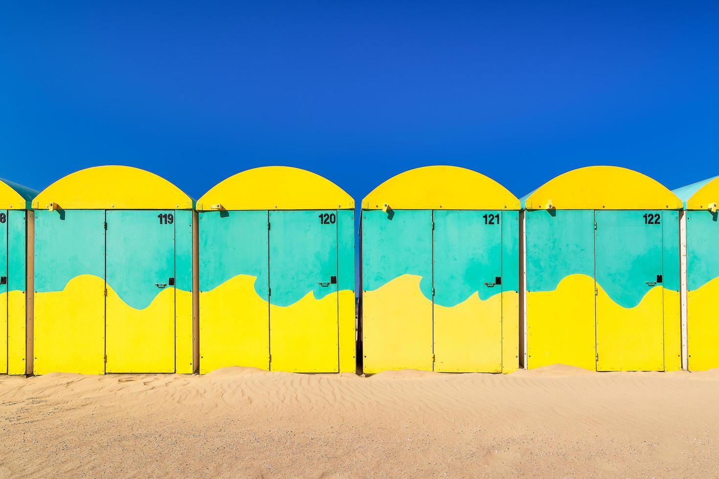 vista panorámica de cabañas de playa de colores en la playa de dunkerque, francia contra el cielo azul de verano foto
