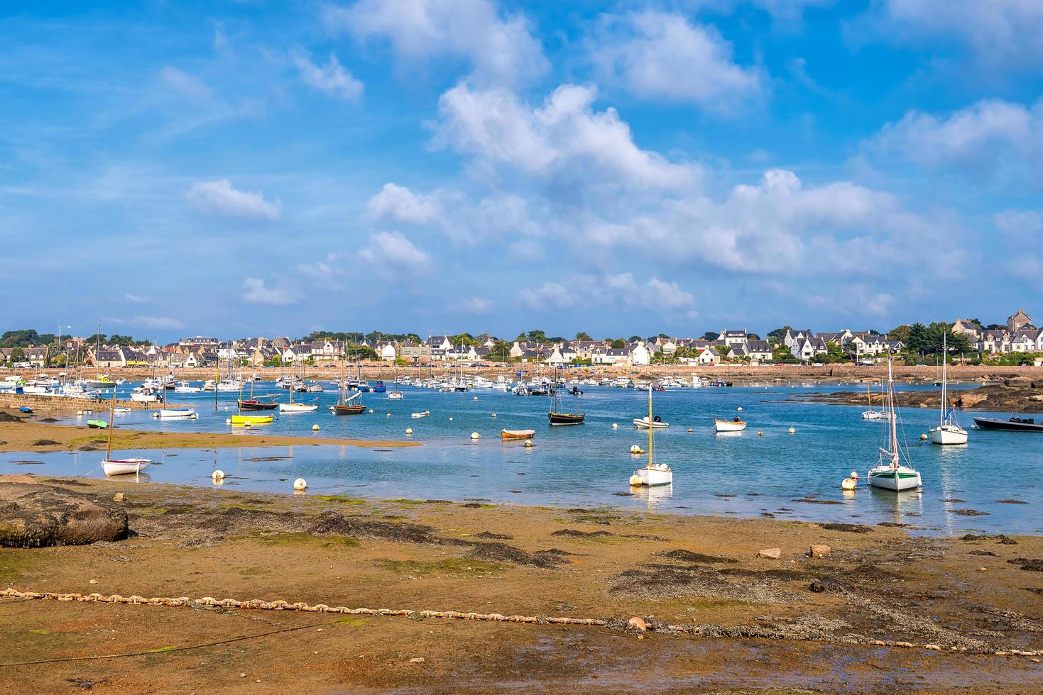 Scenic view of small harbor in Brittany, France at low sea tide against dramatic sky photo