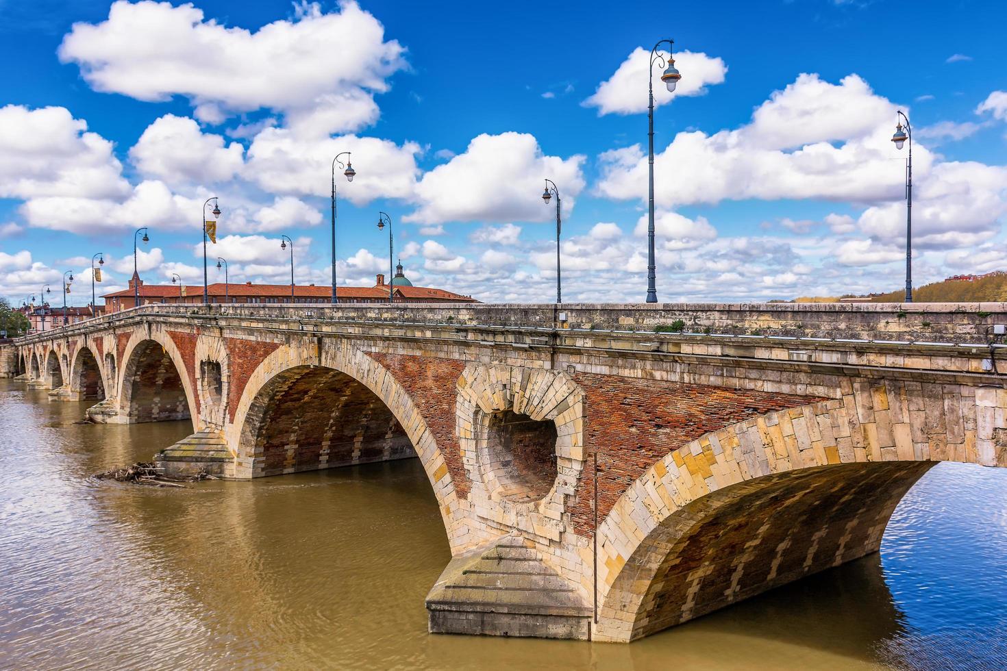 Scenic view of old bridge in Toulouse against spring dramatic sky photo
