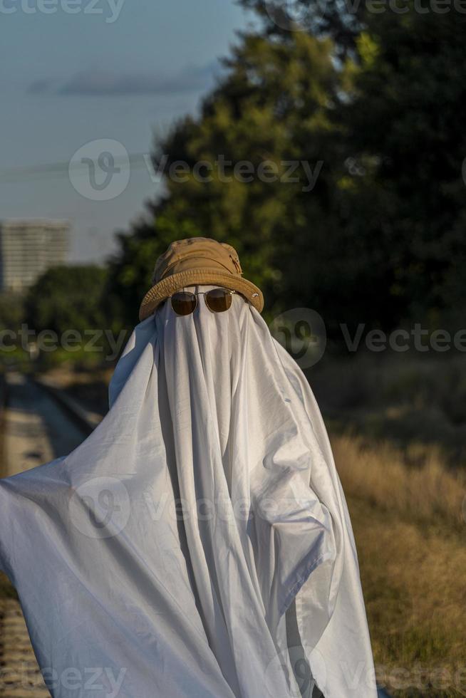 ghost in the countryside enjoying the sun and the train passing behind, train tracks photo