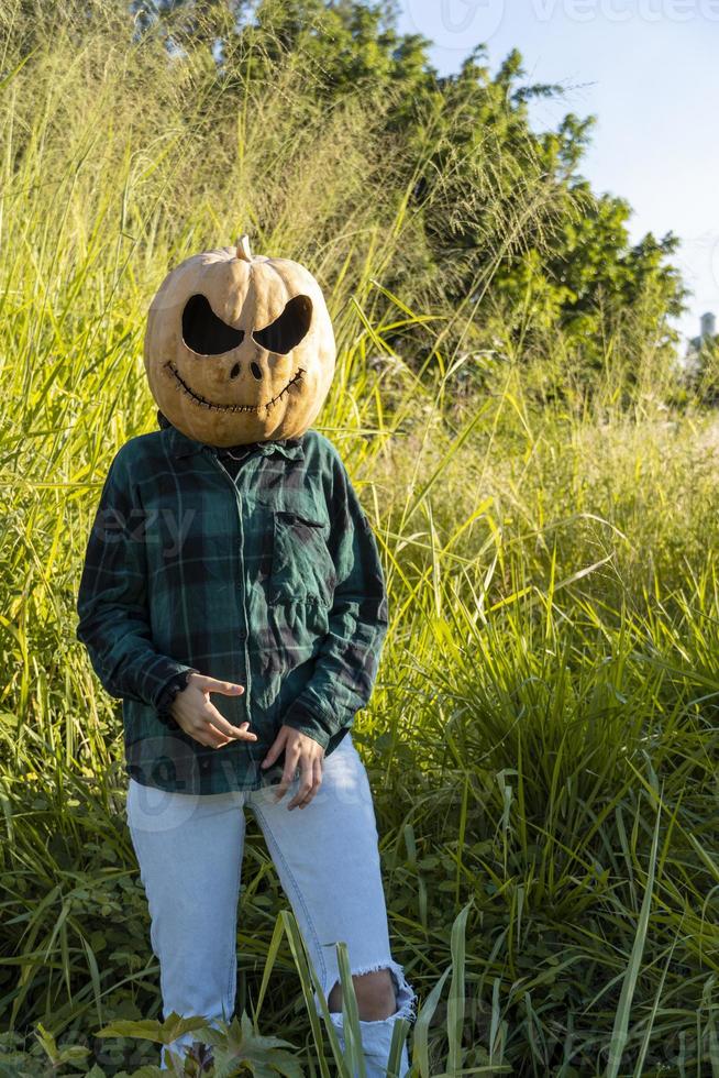 mujer joven con cabeza de calabaza después de cortarla y ponerle cara, halloween, foto