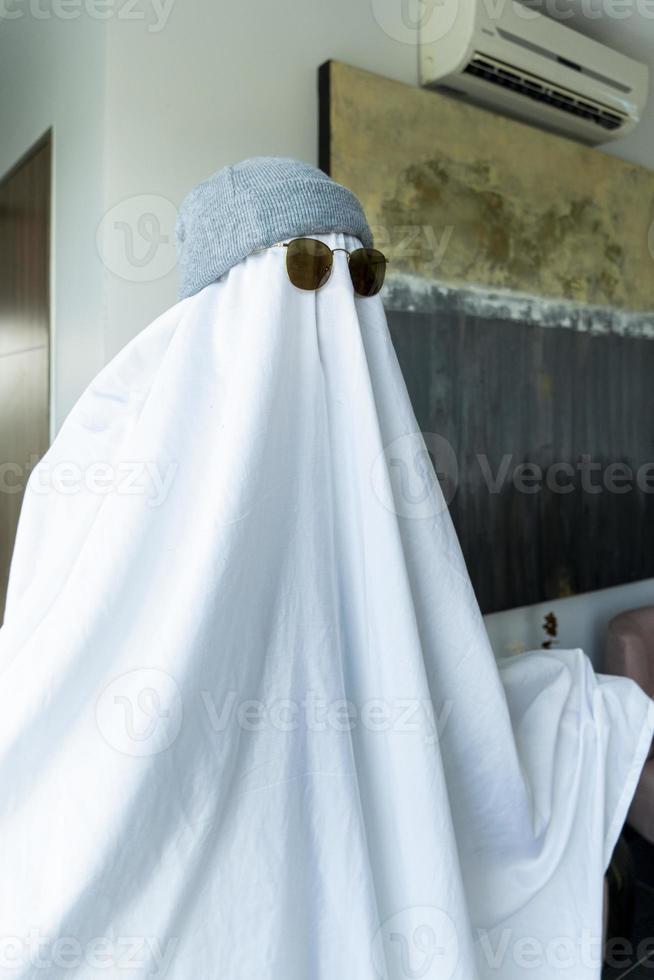 White ghost with black eyes, made from a bedsheet. whit hat photo