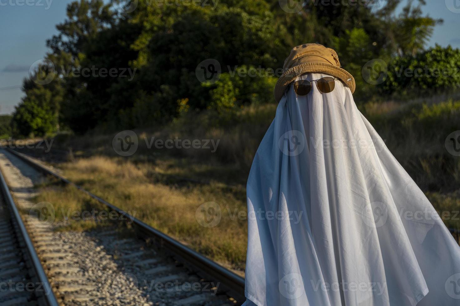 ghost in the countryside enjoying the sun and the train passing behind, train tracks photo