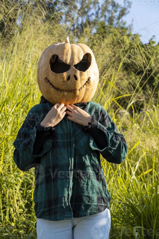 young woman with a pumpkin on her head for halloween, day of the dead, mexico photo