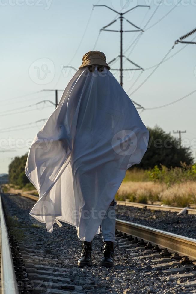 ghost in the countryside enjoying the sun and the train passing behind, train tracks photo