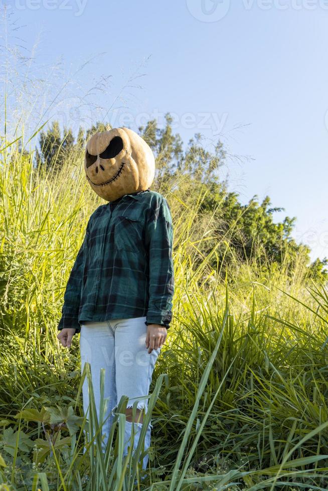 young woman with pumpkin head after cutting it off and putting a face on it, halloween, photo