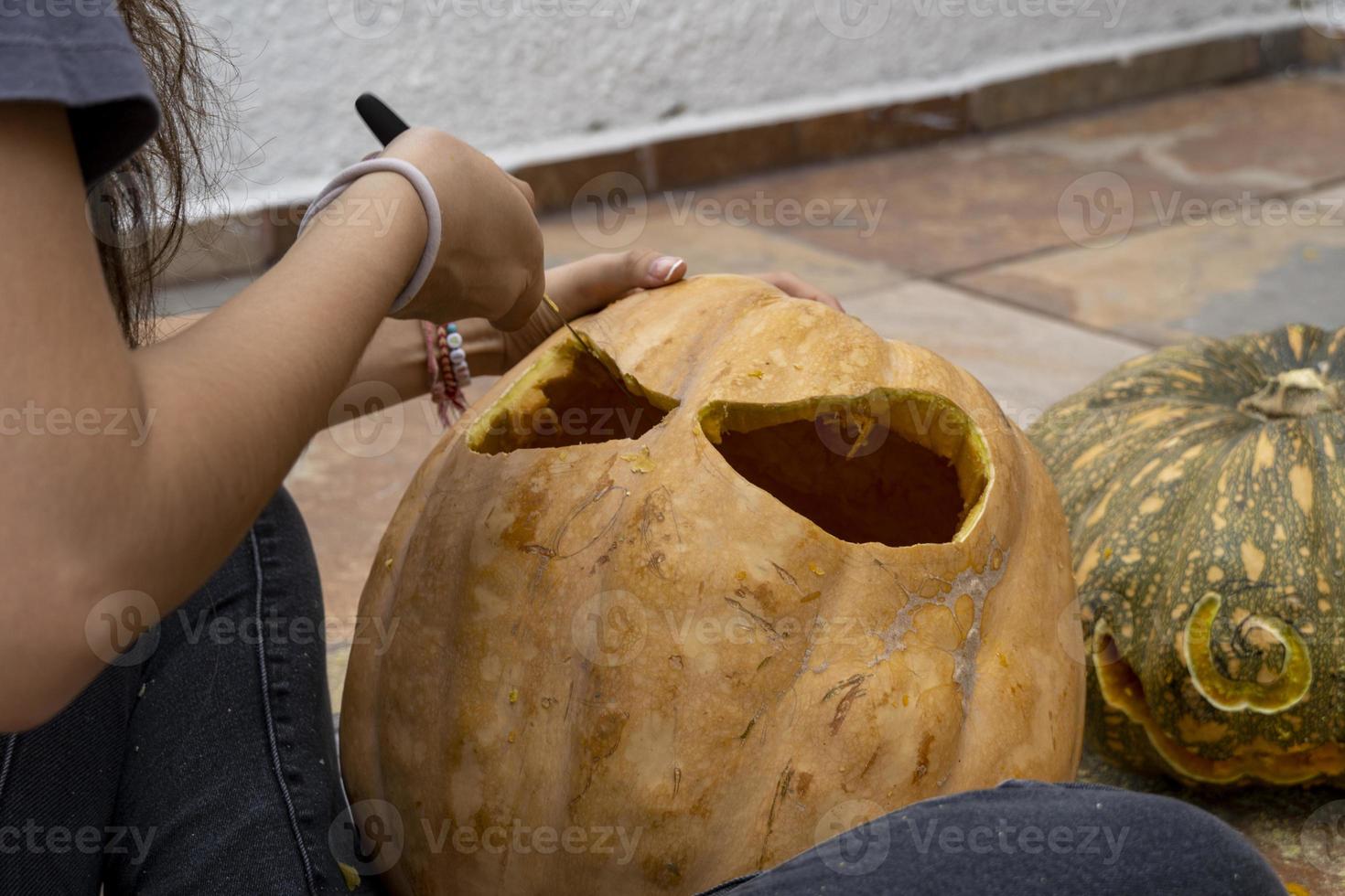 calabaza de halloween tallada, linterna jack, con herramientas para tallar. risa espeluznante, cabeza aterradora. foto