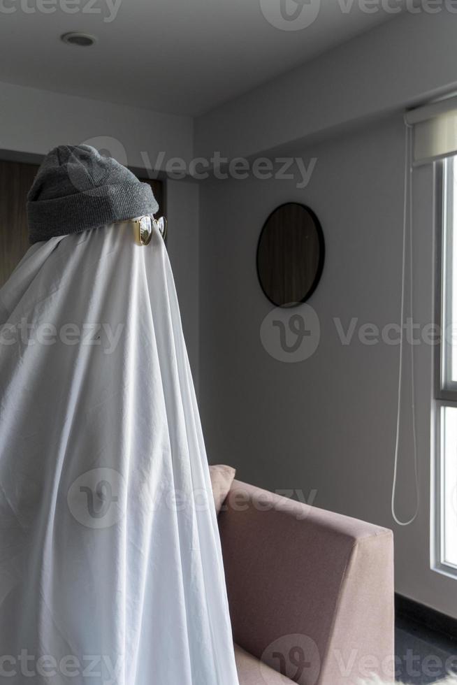 White ghost with black eyes, made from a bedsheet. whit hat photo