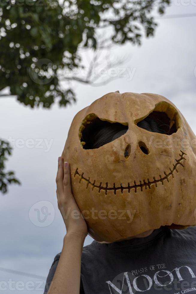 young woman with a pumpkin on her head for halloween, day of the dead, mexico photo