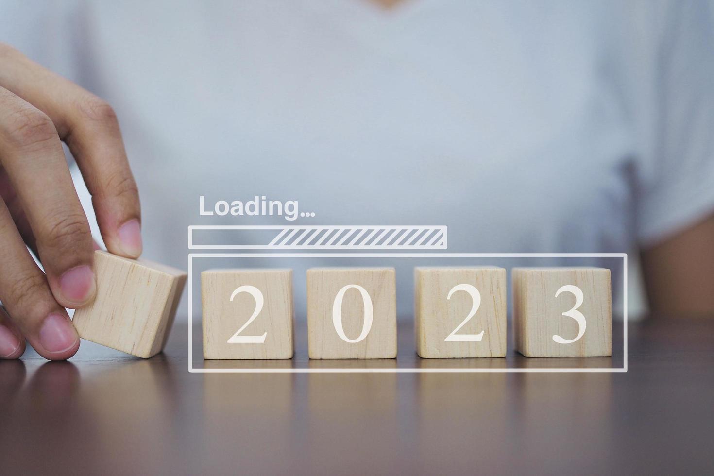 Loading new year 2023 with 2023 wooden blocks on table. Start the new year 2023 with a business goal plan. photo