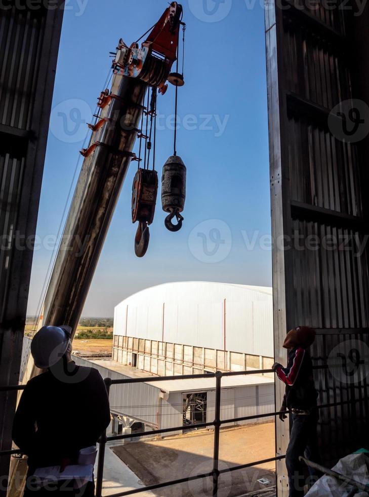 Hoist of crane at the window of industrial plant photo