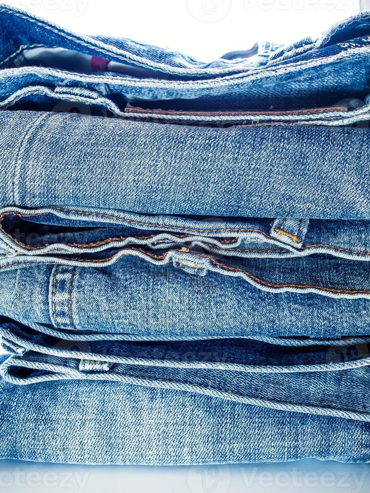 Pile of blue jeans, fabric texture photo