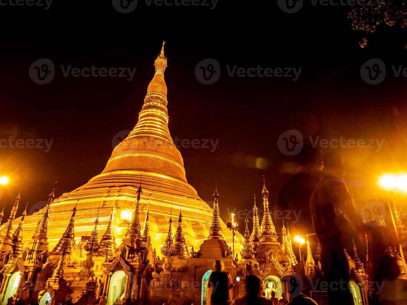 las pagodas doradas y los mondops se iluminan a la luz de la noche foto