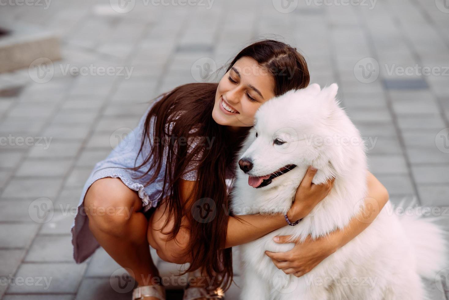 Woman hugs a big dog at sunset photo