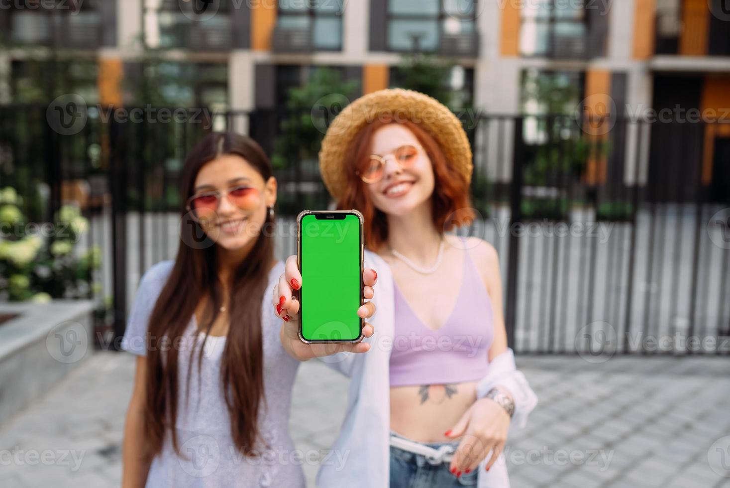 Girlfriends shows their phone to the camera photo