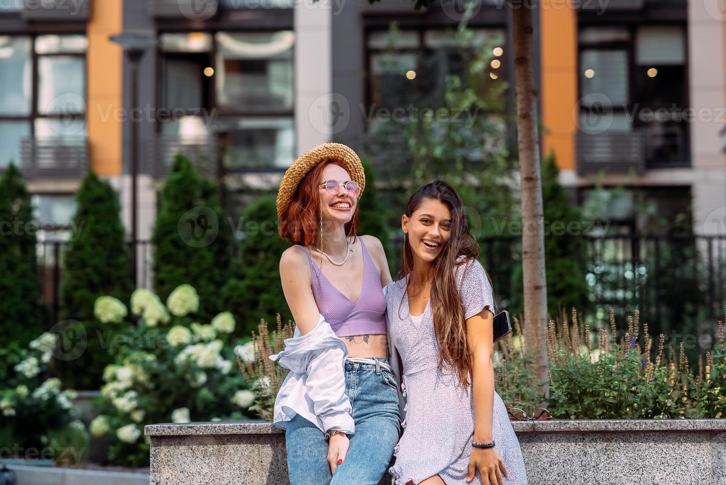 Two young women pose against the background of a building photo