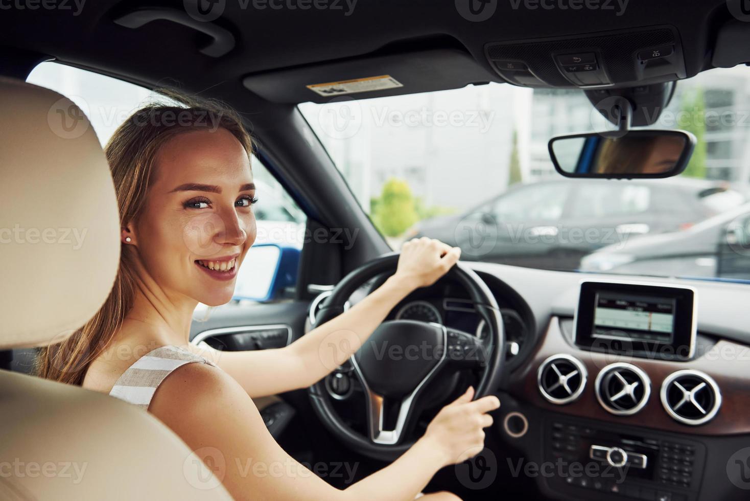 mujer conductora dentro de un automóvil moderno. probando auto nuevo foto