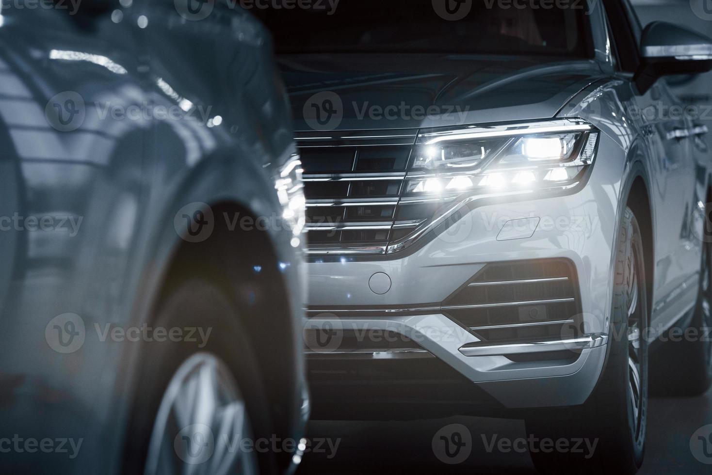Modern technology. Particle view of modern luxury cars parked indoors at daytime photo