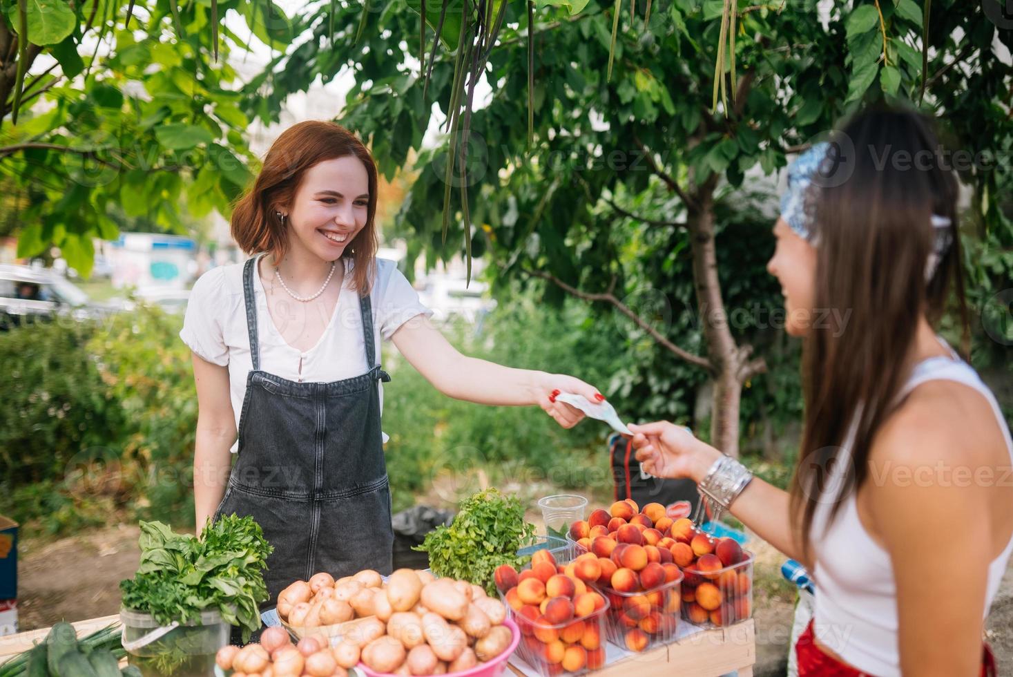 Seller woman offers fresh and organic vegetables farmers market. photo