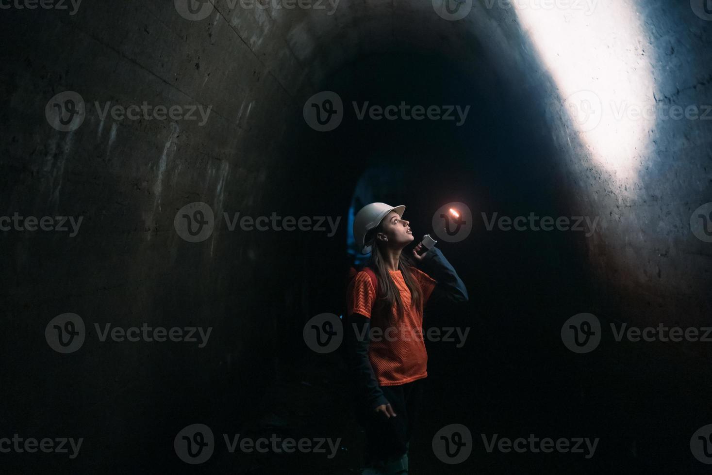 mujer excavadora con linterna explora el túnel foto