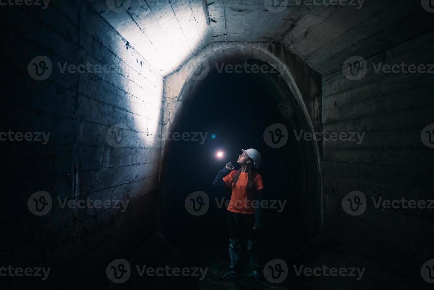 mujer excavadora con linterna explora el túnel foto