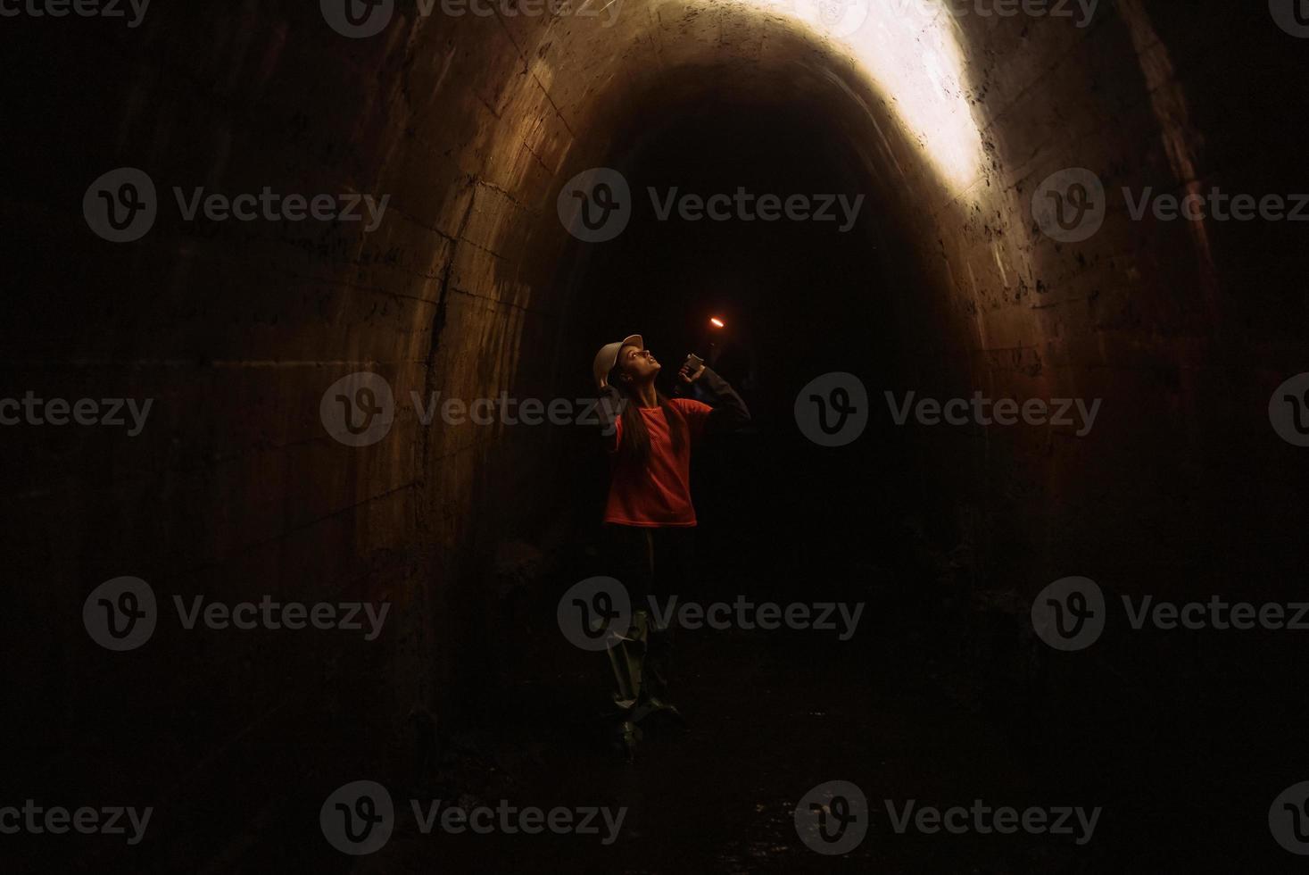 Female digger with flashlight explores the tunnel photo