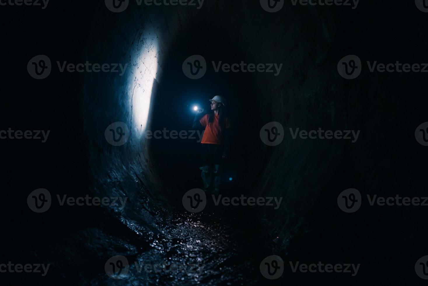 mujer excavadora con linterna explora el túnel foto