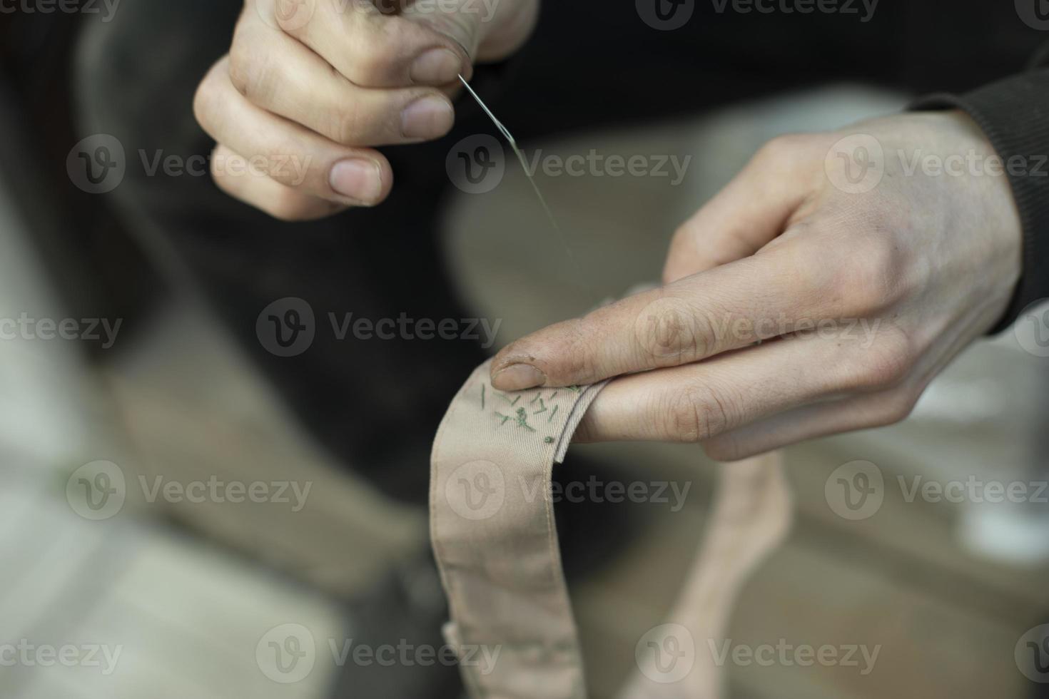 Sewing tape. Collar stitching in army. Work of weaver. photo