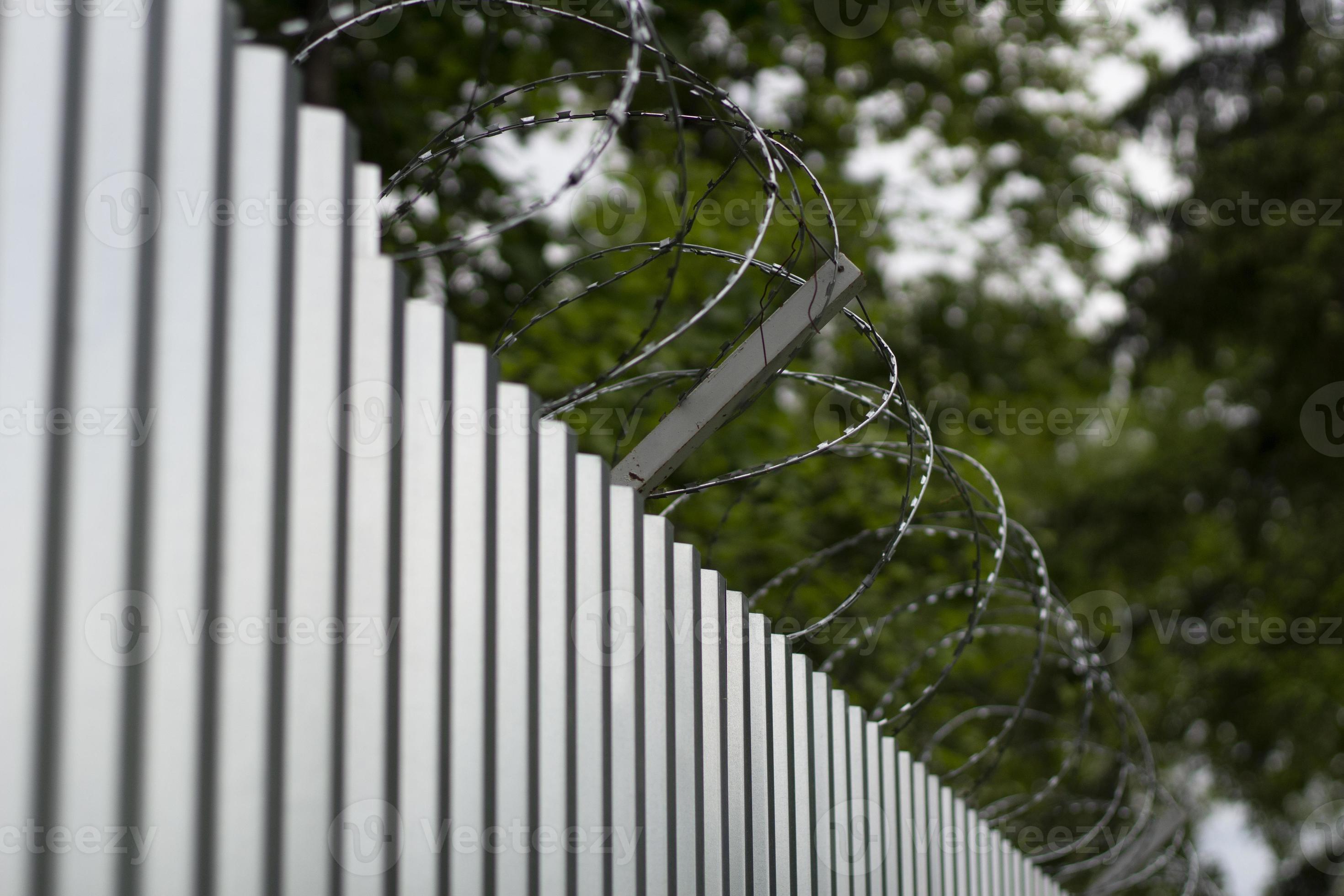 Steel fence with barbed wire. Fence around plant. Private territory