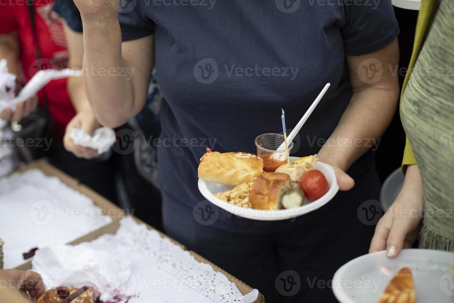 Food in plate in your hand. Man eating on street. Delicious food. photo