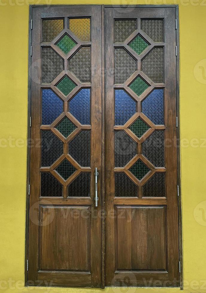 Wooden door, double doors, closed-open Each panel has 4 rectangular wooden compartments decorated with beautiful stained glass. photo