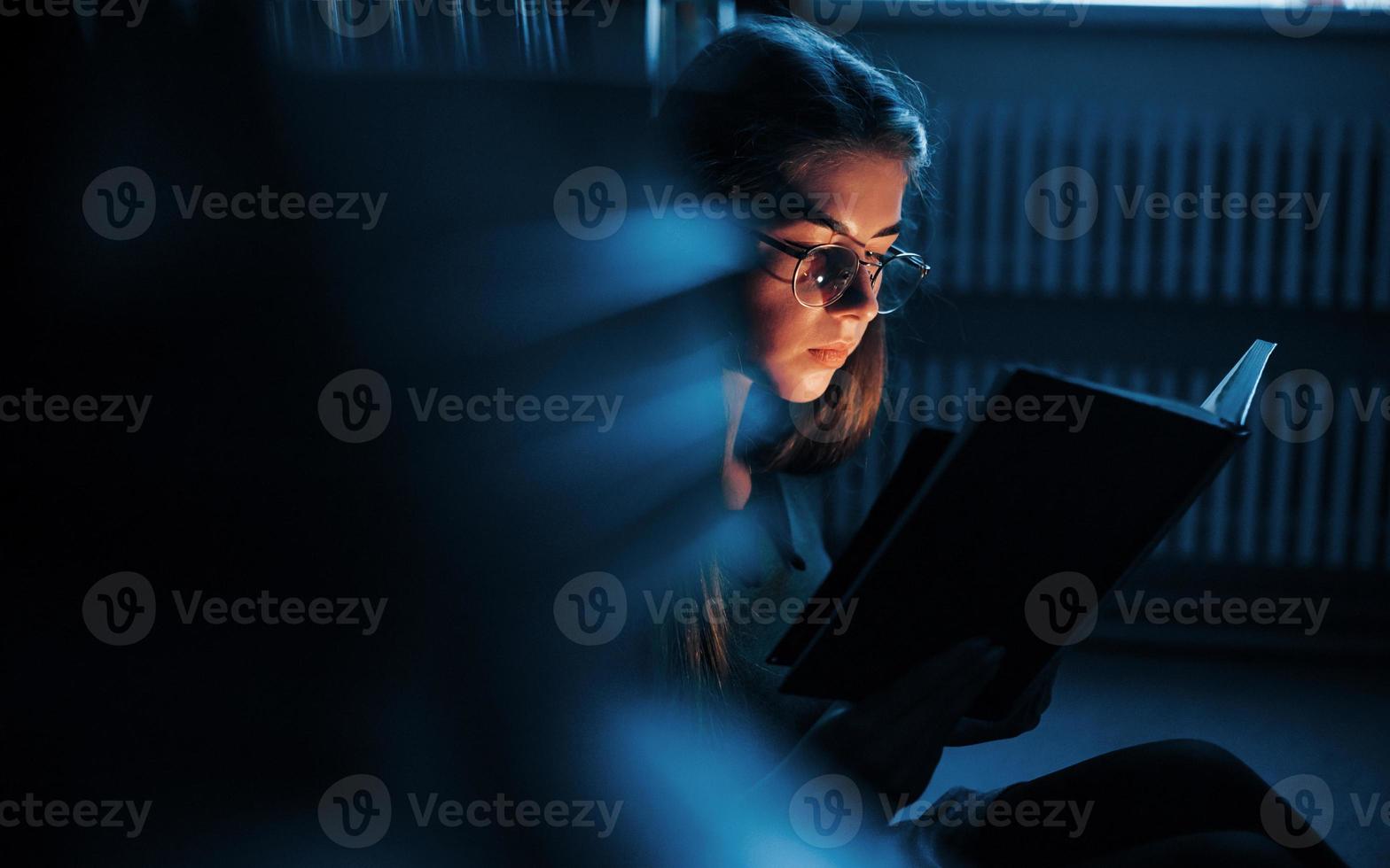 Getting smarter every day. Female student is in library that full of books. Conception of education photo