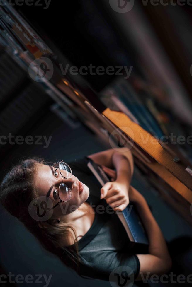 Aerial view. Female student is in library that full of books. Conception of education photo