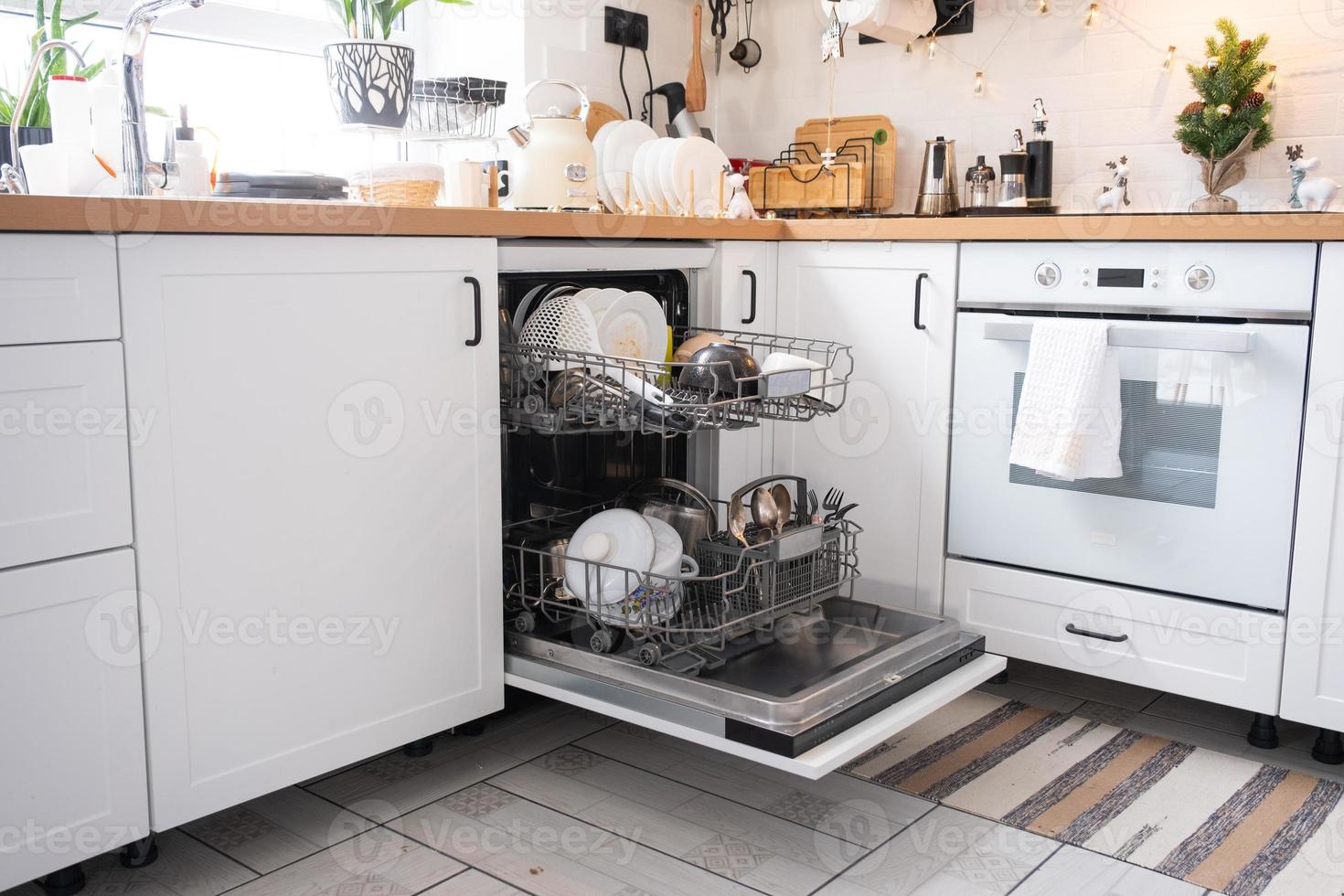 A lot of dirty dishes in the dishwasher. Helping the hostess, economy and ecology. Cleaning in the kitchen for the holidays of Christmas and New Year, after the feast and guests photo