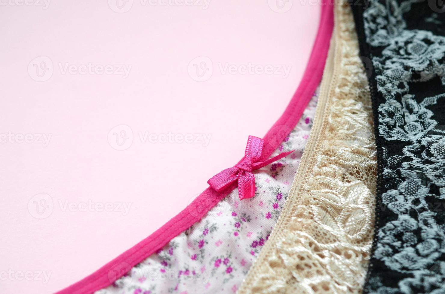 White, black and pink women underwear with lace on pink background with copy space. Advertising for shop of beautiful and comfortable women underwear photo