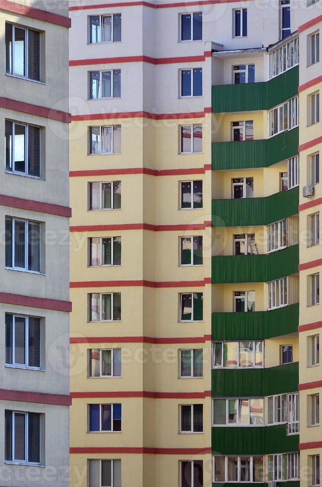 New or recently completed multi-storey residential building with windows and balconies. Russian type of house building photo