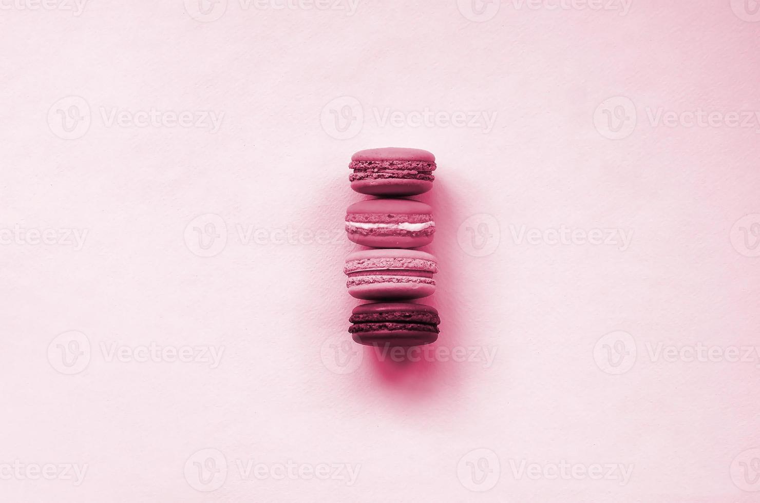 Dessert cake macaron or macaroon on trendy background top view. Flat lay composition Image toned in Viva Magenta, color of the 2023 year photo