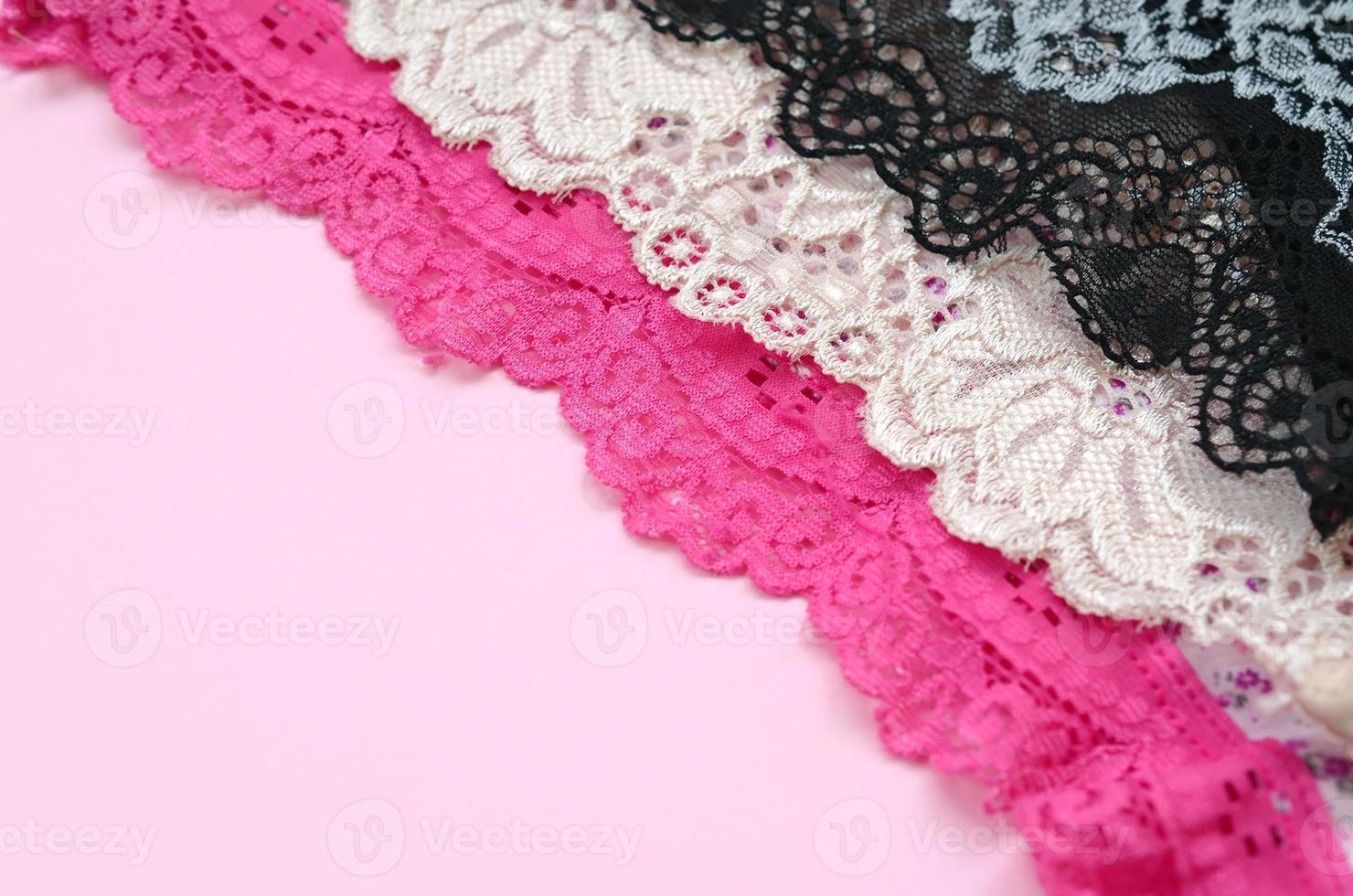 White, black and pink women underwear with lace on pink background with copy space. Advertising for shop of beautiful and comfortable women underwear photo