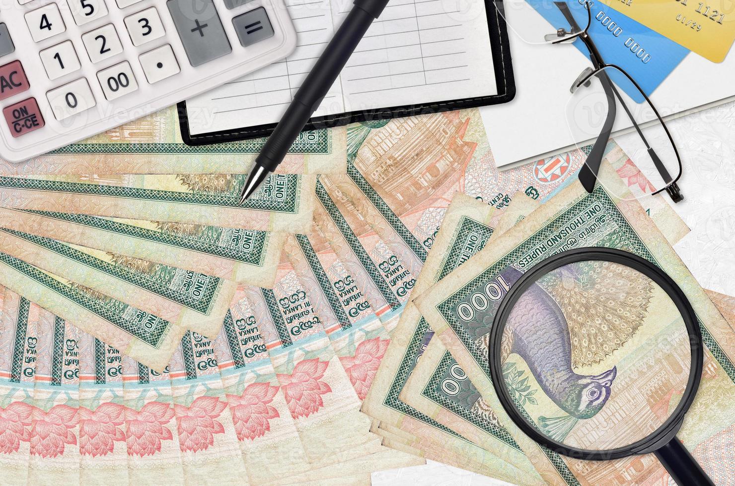 1000 Sri Lankan rupees bills and calculator with glasses and pen. Tax payment season concept or investment solutions. Searching a job with high salary photo