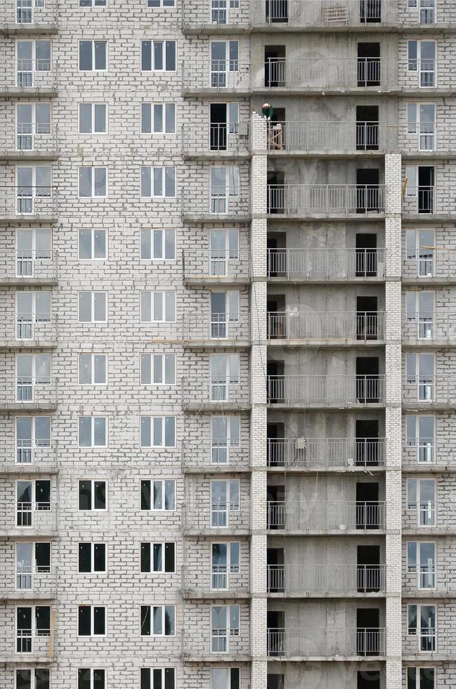 Textured pattern of a russian whitestone residential house building wall with many windows and balcony under construction photo